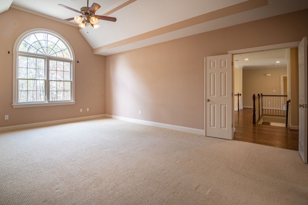 Empty room with wall-to-wall carpet flooring, illustrating carpet cleaning cost by square footage